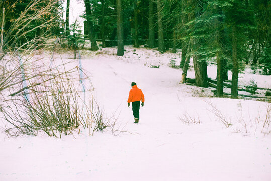 Boy in a red jacket walking on snow, 35 mm