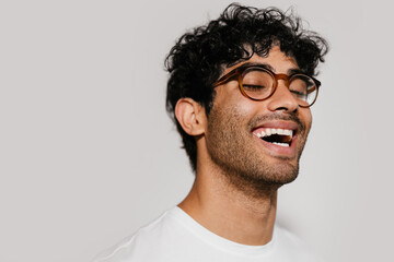 Happy Hispanic man in glasses laughing
