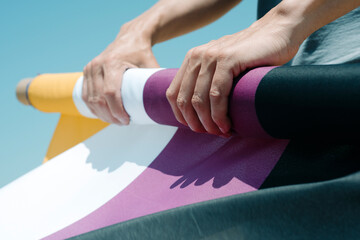 person rolls a non-binary pride flag