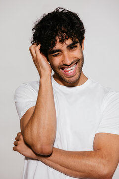 Playful Hispanic man touching hair