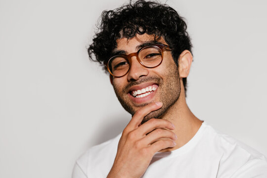 Cheerful Hispanic guy in glasses thinking