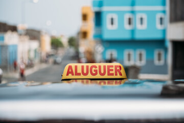 Taxi sign on roof of cab riding along street