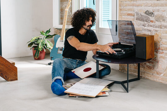 Man listening to vinyl disc at home