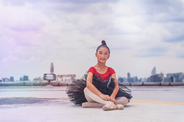 Fototapeta na wymiar ballerina dancer performing ballet dance on rooftop of building in city