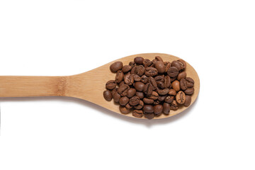 Coffee beans on a wooden spoon on a white background top view