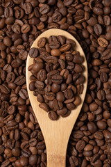 Coffee beans on wooden spoon close-up