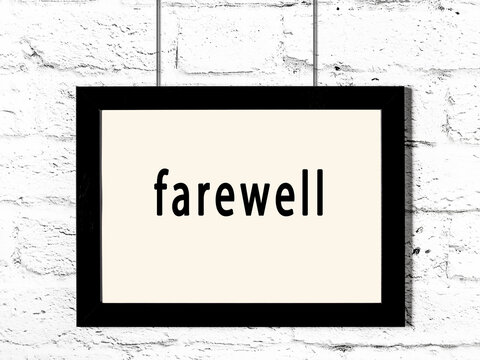 Black frame hanging on white brick wall with inscription farewell