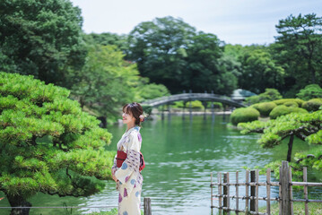 Fototapeta premium 日本庭園を散策する浴衣の女性