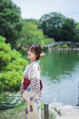 日本庭園を散策する浴衣の女性