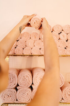 Crop of female manicurist examining rolled up towels