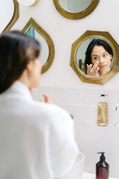 Asian female applying cream in morning