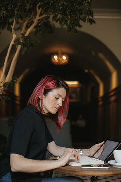 A woman with colored hair and a tablet