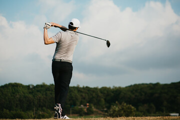 Golfers take the swing shot with a strong stance. looking from behind.