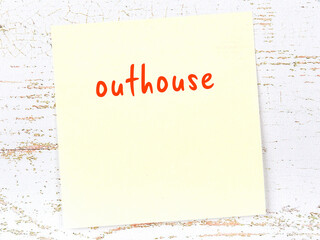 Yellow sticky note on wooden wall with handwritten word outhouse - obrazy, fototapety, plakaty