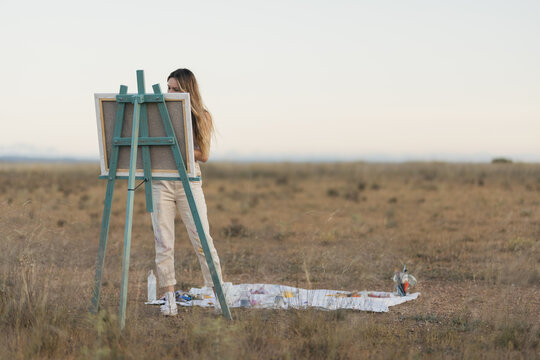 Young woman painting in nature