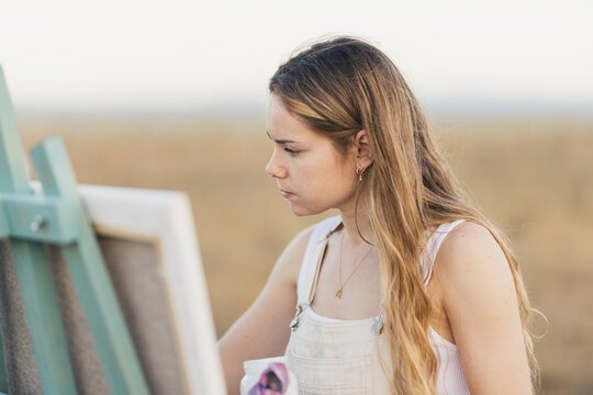 Young woman painting in nature