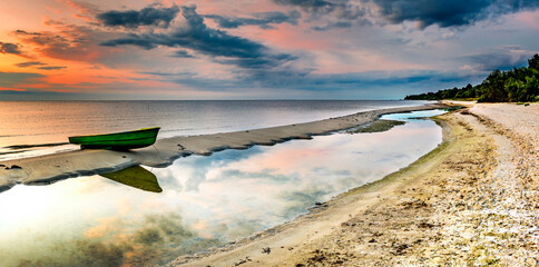 Colorful sunrise with fishing boats anchored on sandy beach of the Baltic Sea