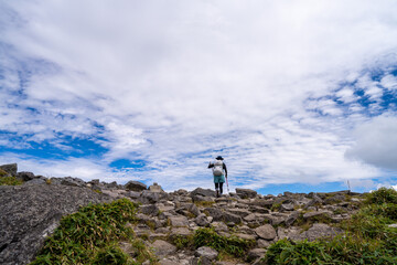 長野県諏訪市の霧ヶ峰で女性が登山している風景 A woman climbing a mountain in...