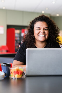 smiling aboriginal woman using computer