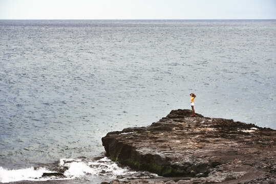 Woman standing in a cliff seashore