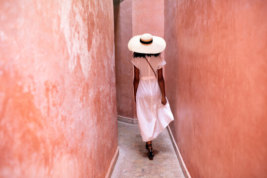 Woman walking through clay walls in marrakesh