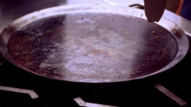hand putting corn tortilla on comal