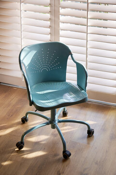 Close-up rotating work chair by the blinds illuminated by the sunset