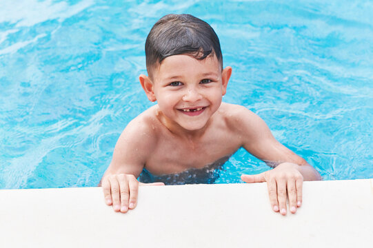 Smiling little boy swimming in a pool