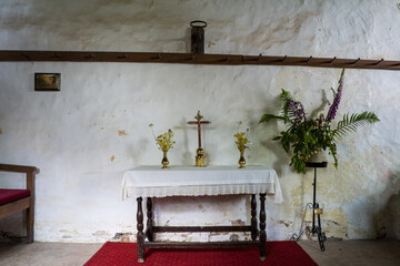 A small alter and cross in a historic medieval church.