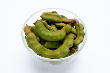 Young tamarind in glass bowl on white background.