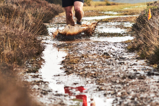Trail runner splashes through muddy track 