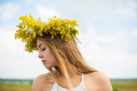 Woman With Floral Wreath Standing On Meadow