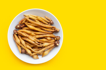 Finger root on in white plate on yellow background.