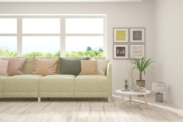 Fototapeta premium Stylish room in white color with sofa and summer landscape in window. Scandinavian interior design. 3D illustration