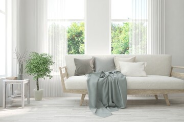Fototapeta premium White living room with sofa and summer landscape in window. Scandinavian interior design. 3D illustration