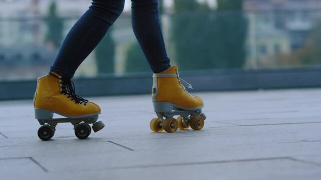 Closeup woman legs doing exercise outside. Sporty girl riding on rollerblades.