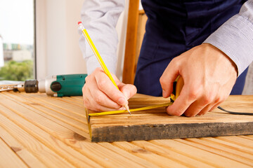 Handyman in blue uniform works with electricity automatic screwdriver. House renovation conception.