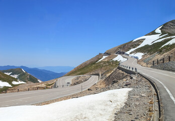 Tateyama Kurobe Alpine Route with beautiful landscape snow mountains., the tourists bus move along the japan alps snow wall with blue sky background. Toyama city, Japan.