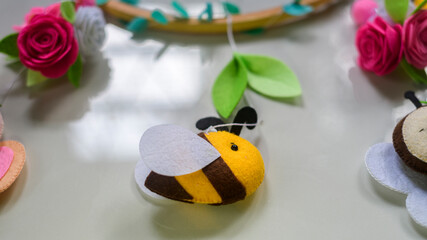 Cute prop for baby cot mobile closes up. Felt plush bees with flowers design.