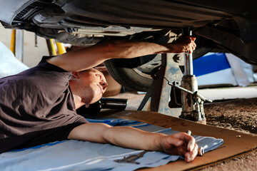 Fototapeta na wymiar An auto mechanic works in a garage. Car repair
