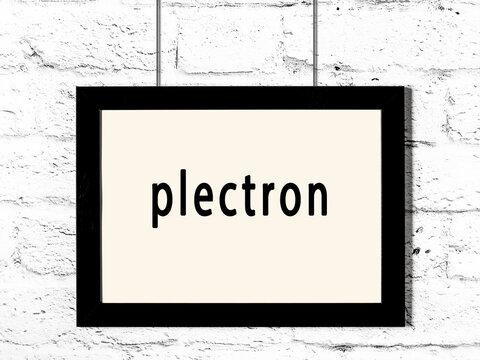 Black frame hanging on white brick wall with inscription plectron