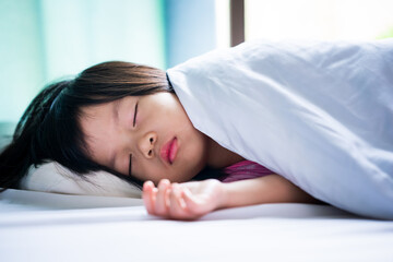 Portrait of Asian beautiful girl sleeping in white bed. Baby sleeping in blanket. Child aged 4-5 years old.