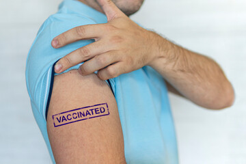 Caucasian man, patient with blue stamp vaccinated on hand. Concept of people vaccination for covid-19 coronavirus, flu, infectious diseases. Injection. Mandatory mass vaccination of world population - obrazy, fototapety, plakaty