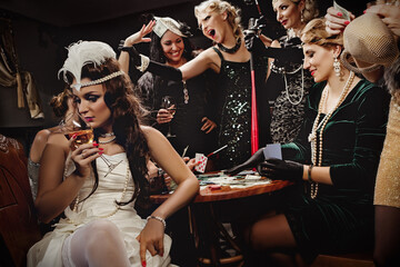 Fototapeta Beautiful women in evening dresses plaing poker obraz