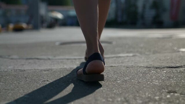 The legs of a tourist, a walk along the street. the concept of travel. close-up of a woman leg. sandals on the bare foot