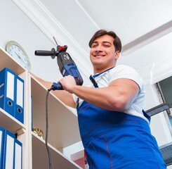 Young worker repairing shelves in office