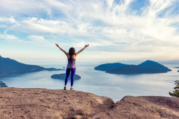 Adventurous Caucasian Adult Woman hiking on top of a mountain during a colorful sunny summer day....