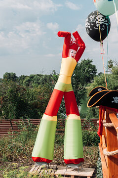 Vertical Shot Of Inflatable Tube Man With Pirates Balloon And Hats Outdoors