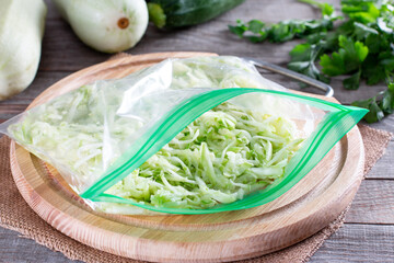 Grated zucchini in a plastic bag ready to be frozen on a table. Frozen Food Conce