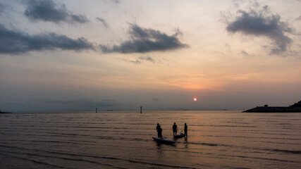 Fototapeta premium At sunset, swimmers play on the beach 